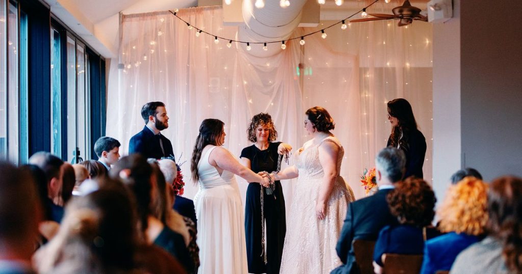 Victoria and Kelly exchanging vows in the Pinstripes DC Canal Room with canal views behind them