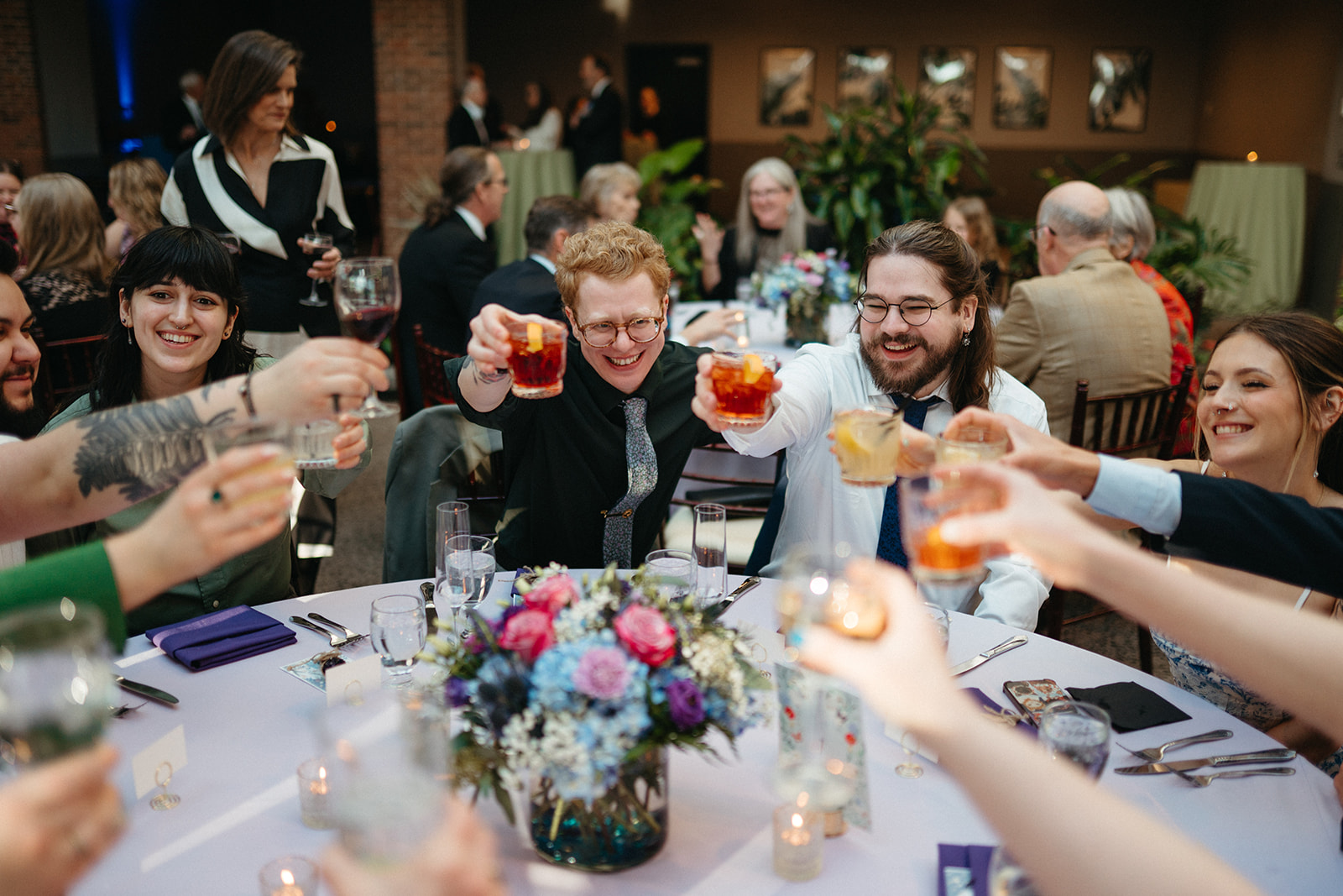 Couple cheering at table with guests