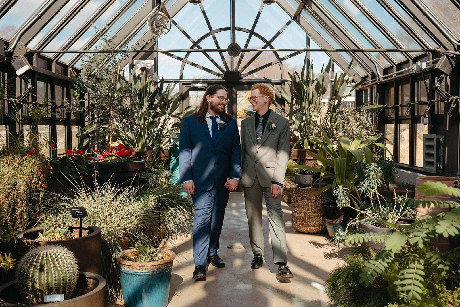 couple in atrium gardens holding hands looking at each other while walking