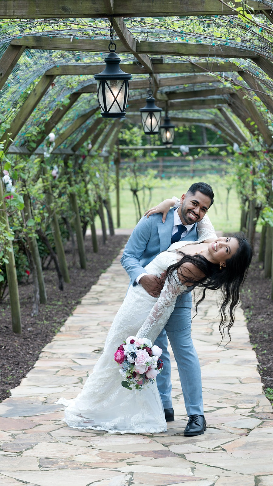groom dipping bride under vine arch way