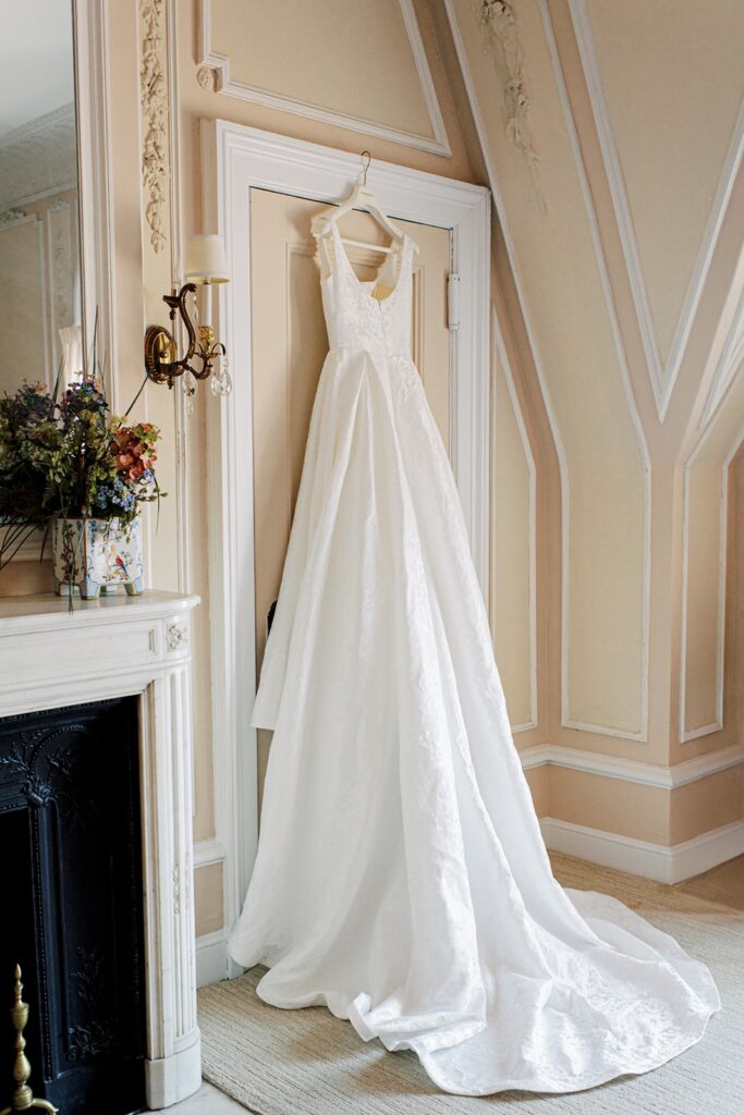 Wedding gown hanging on a door frame.