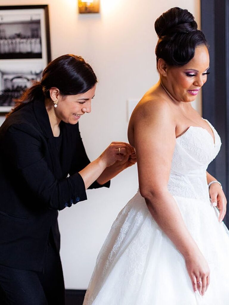 Kinfete Weddings & Events planner, Angela helping a bride with the back of herwedding dress.