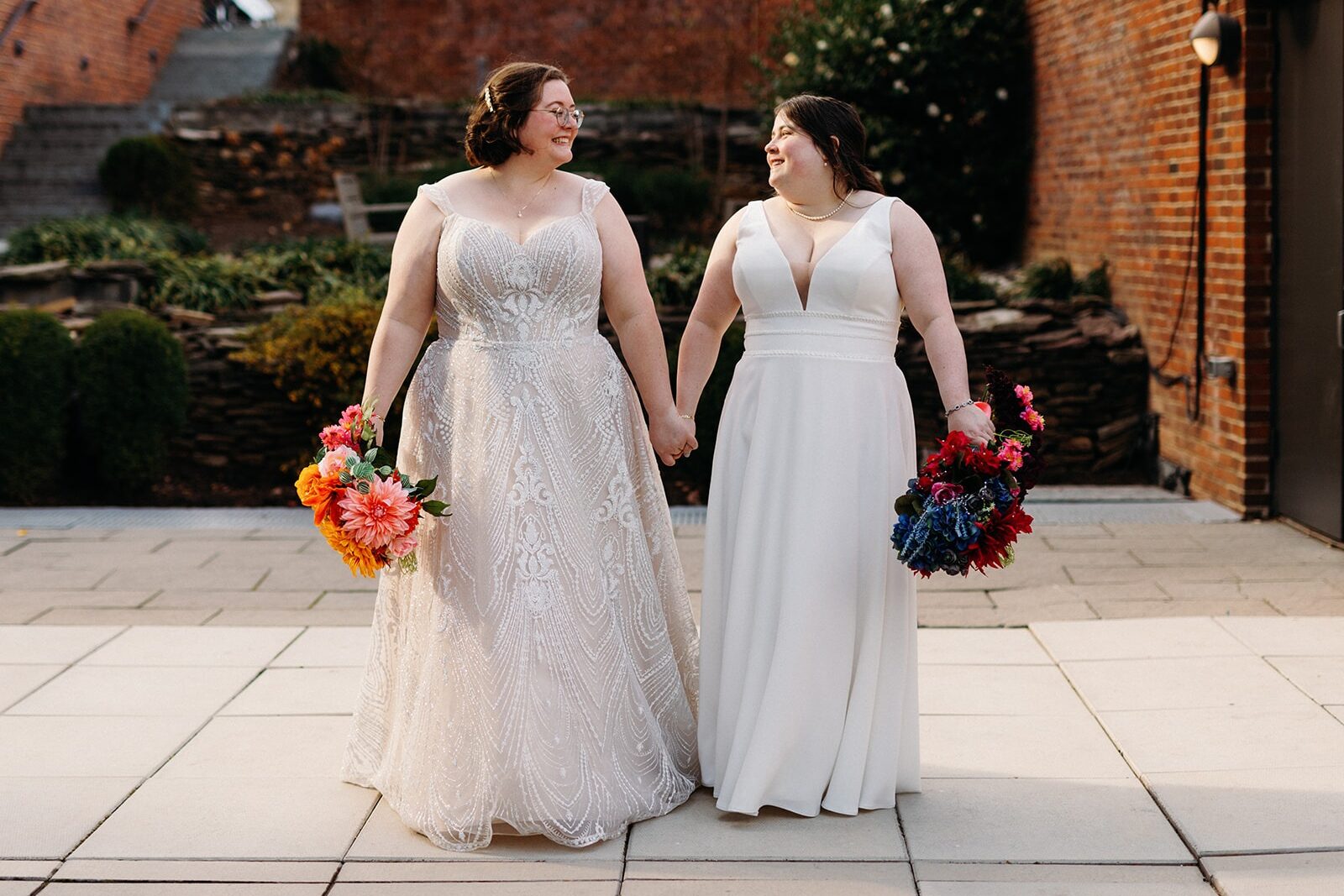 DC Pinstripes Wedding couples portrait in front of brick holding bouquets.