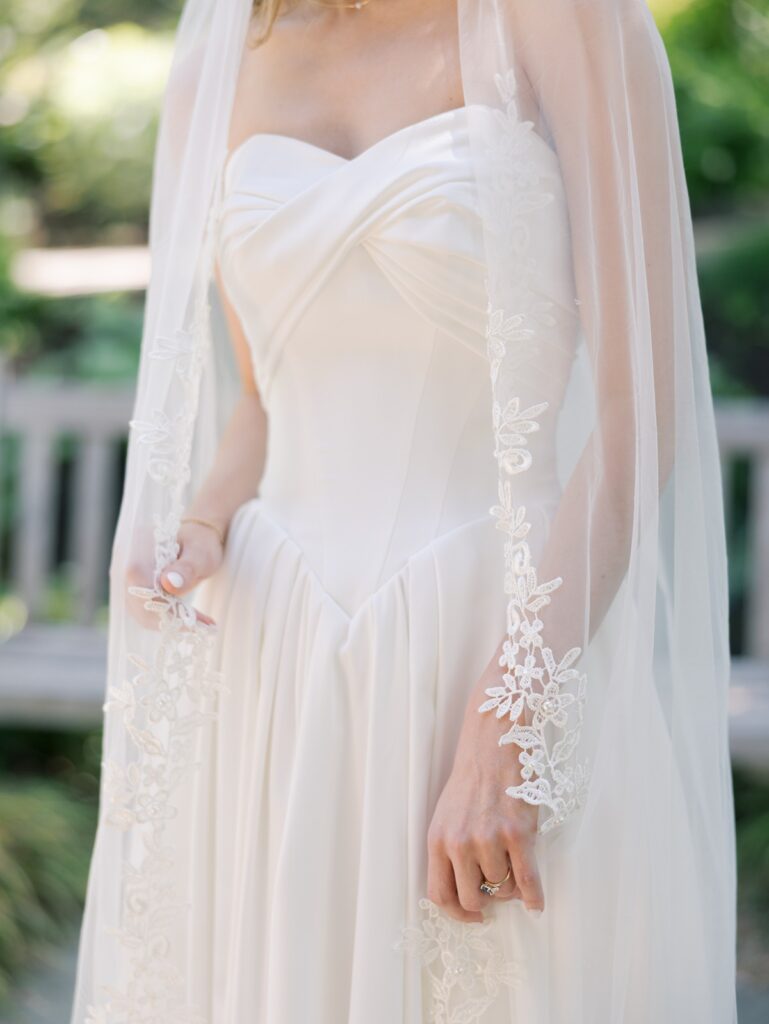 Woman posing in a strapless wedding dress with a veil.