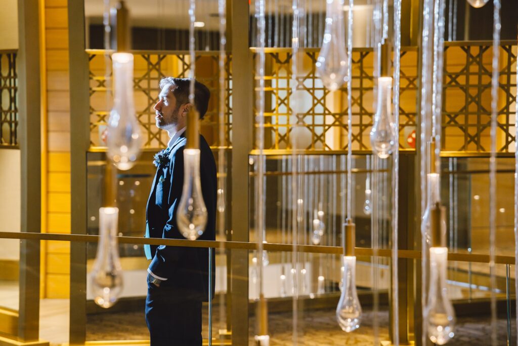A groom stands in a decorative room at the Intercontinental DC Wharf Hotel.