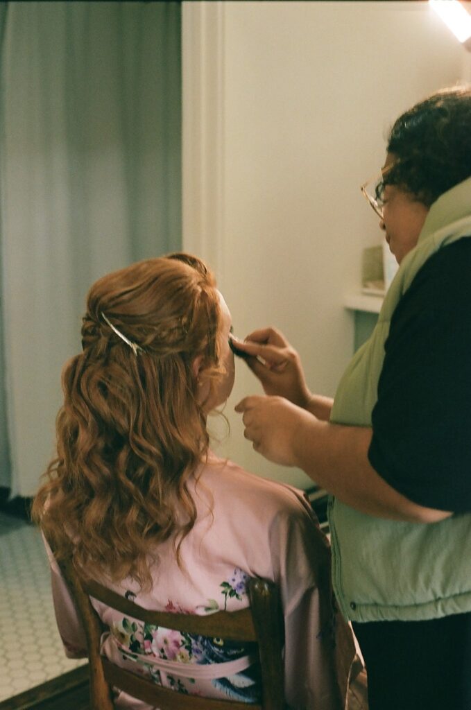 A spouse-to-be getting her makeup done in the Showalter's Orchard and Greenhouse farmhouse