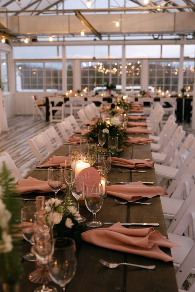 Wedding table scape with terracotta napkins, white shares, and romantic lighting