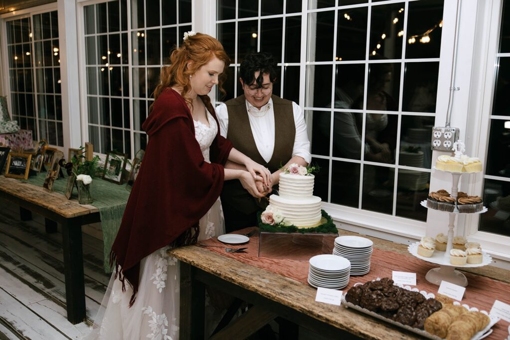 A newlywed couple cuts their cake together